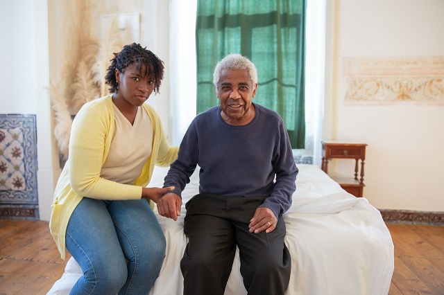 Photograph of caregiver siting with elderly man