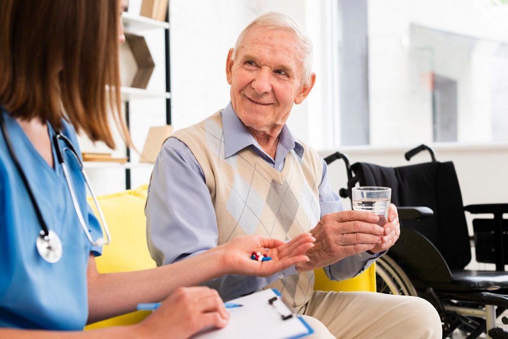 Photograph of nurse giving drugs to smiling elderly man