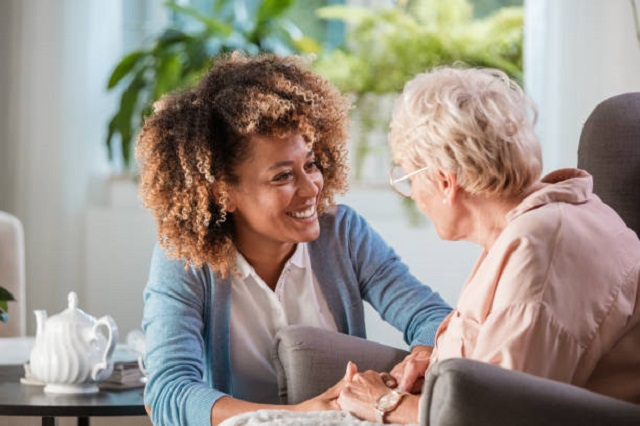 Photograph of caregiver smiling at elderly lady